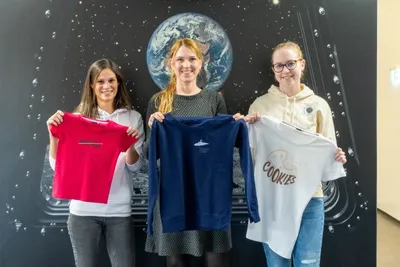 3 Frauen halten T-Shirt in der Hand