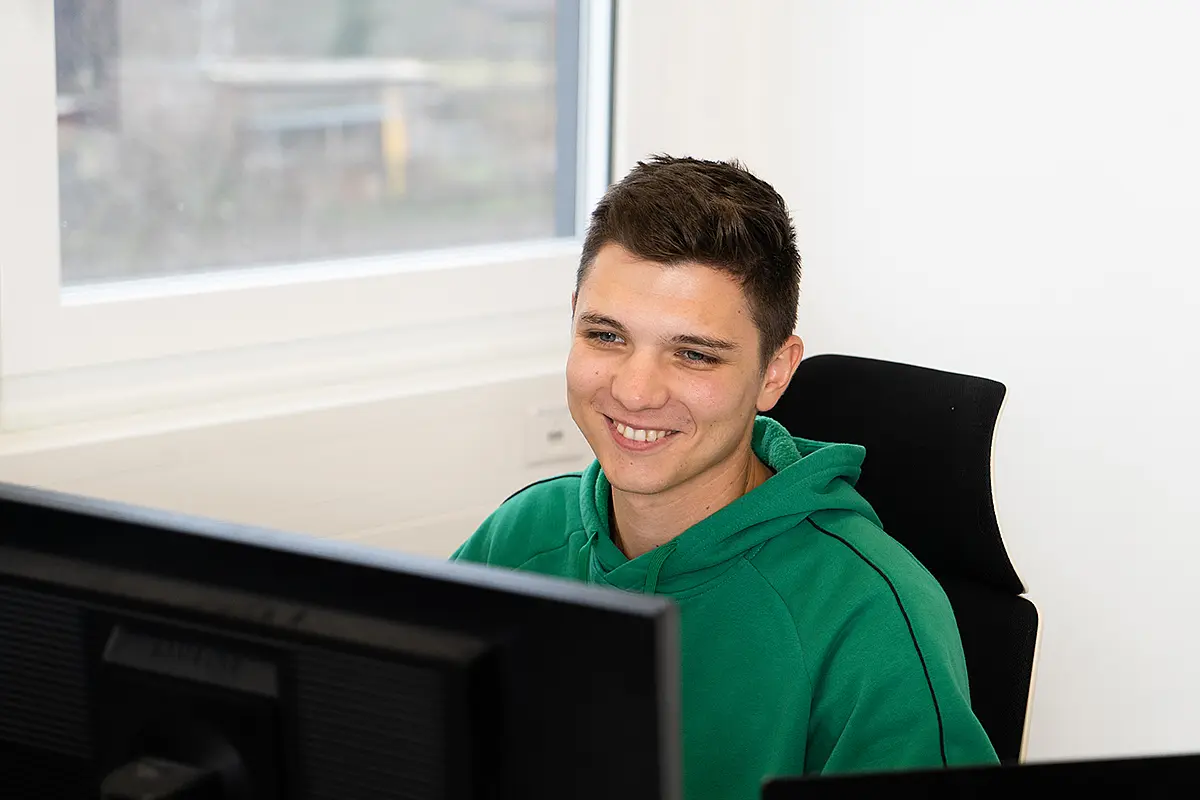 Mann lächelt in Computer hinein